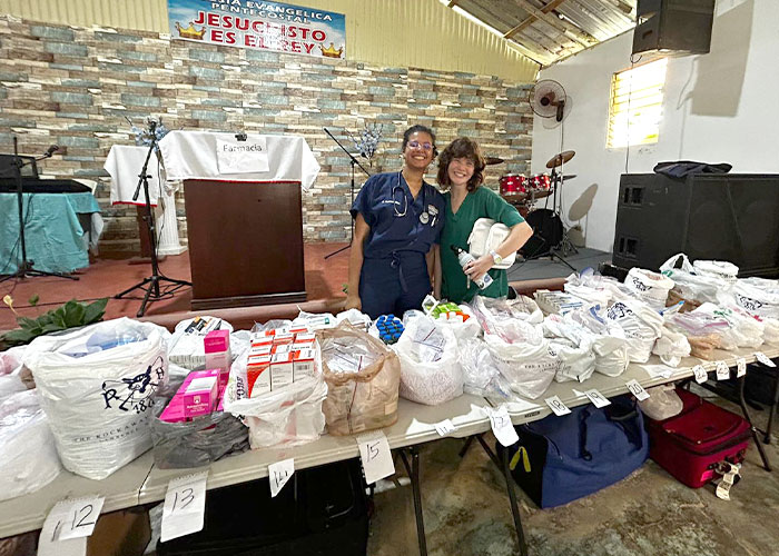 NYITCOM students Claudia Guerrero (left) and Angelica Maiers (right) help to set up the mobile pharmacy at a local church in the Dominican Republic.