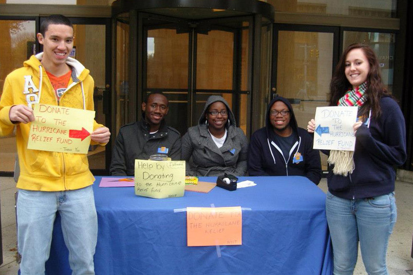 <strong>Alumnus Remembers Hurricane Sandy Relief</strong> Larry Kamguia (M.A. '13), assistant director of career services (pictured second from left), counts a difficult period as one of his proudest experiences at NYIT: when Hurricane Sandy hit the New York tri-state area in 2012. The storm made landfall on Oct. 29 and affected everyone at NYIT. "It was my first time experiencing a hurricane," said Kamguia. "Many of my classmates saw their homes destroyed by Hurricane Sandy. Our fundraiser was a way for me and other students to show our support for affected families. It's this sense of solidarity during hard times that makes me proud to be part of the NYIT community."