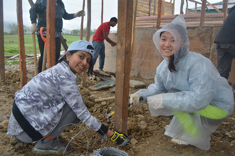 From left: NYIT students Hinali Shah and Yan Xu installing barbed wire.