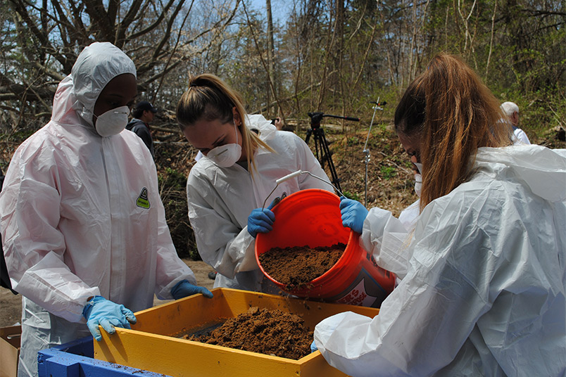 Students bring buckets of dirt to sift through.