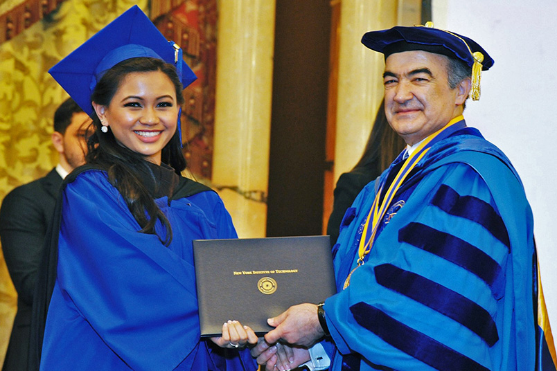 Interim President Rahmat Shoureshi, Ph.D., presents a student with her degree.