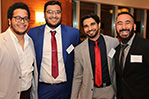 Speakers Haji Arif (second from left) and Nassir Etout (far right), smile for the camera with fellow alumni.