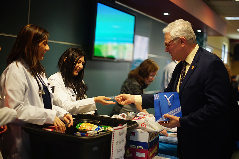 In Riland Café, President Foley greets volunteers and donates books to the Reach Out and Read program and food to Island Harvest, the largest hunger relief organization on Long Island.