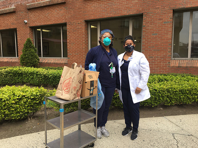 Two frontline health professionals receiving supplies.