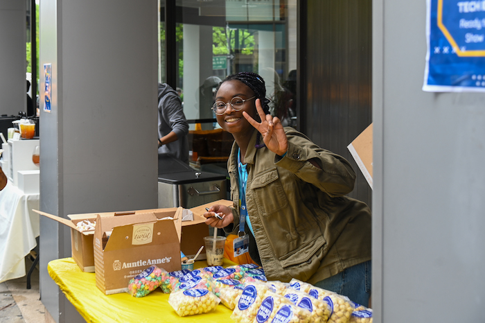Student leader Addie Owusu serves gourmet popcorn and pretzels to those in attendance at New York City Street Fair.