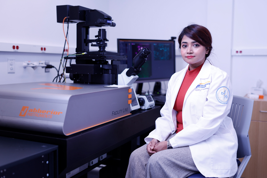 A research poses with a high-tech microscope.