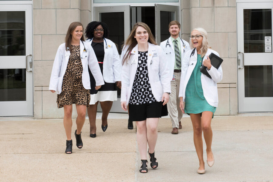 Students walk near the outside of the NYITCOM-Arkansas building on the Arkansas State University campus.