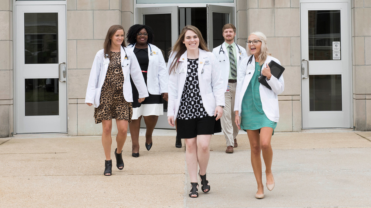 Students walk near the outside of the NYITCOM-Arkansas building on the Arkansas State University campus.