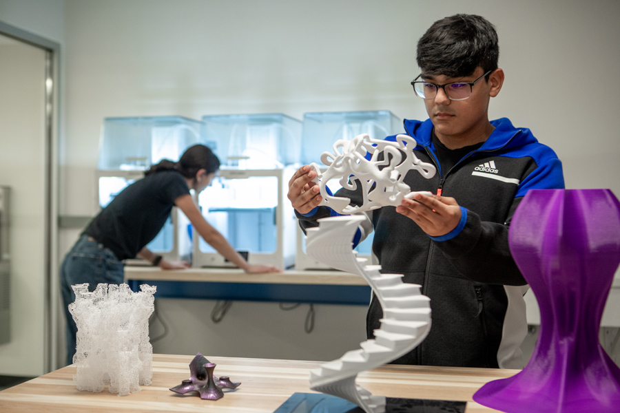 Two students create 3-D printed projects in New York Tech's Fab Lab.