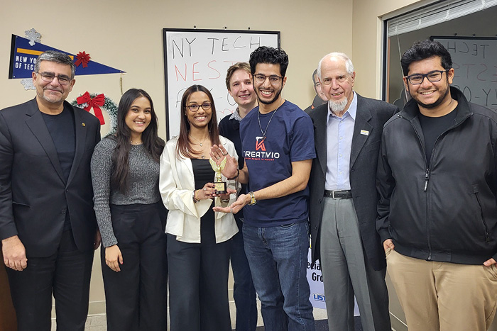 A group of student entrepreneurs receive a trophy for their work.