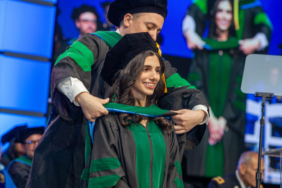 Student being hooded by professor