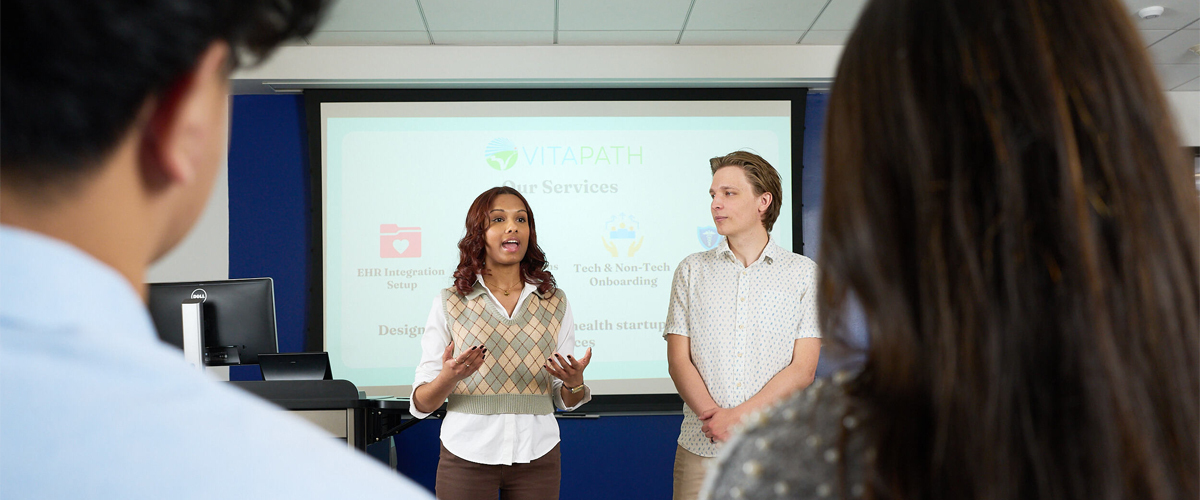 Two student entrepreneurs are presenting their business idea in a classroom.