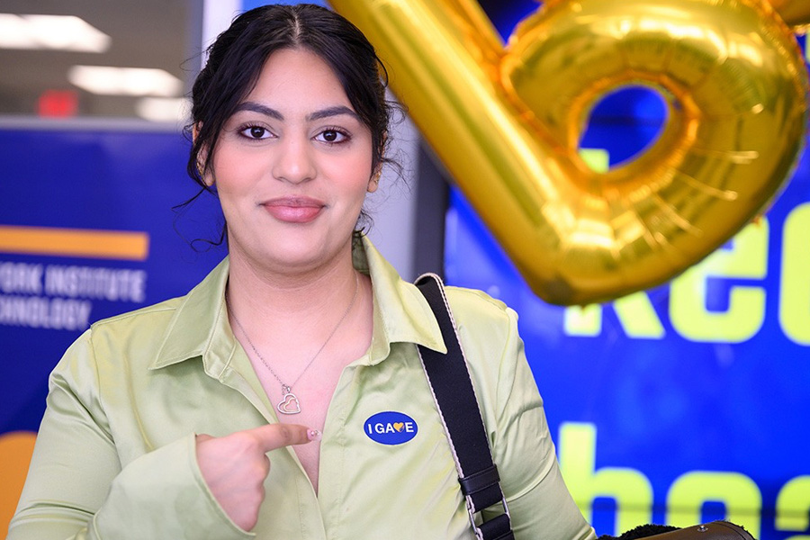 Woman pointing at I Gave sticker on her shirt