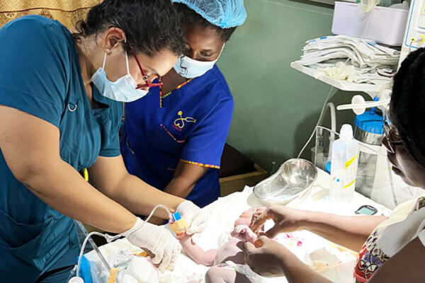 Medical students helping infant.