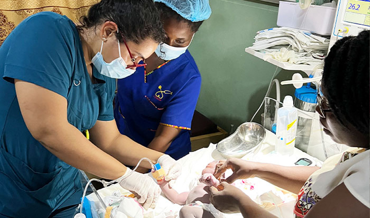Medical students helping infant.