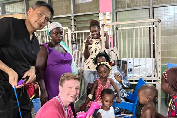 Medical students taking picture with patient and their children.