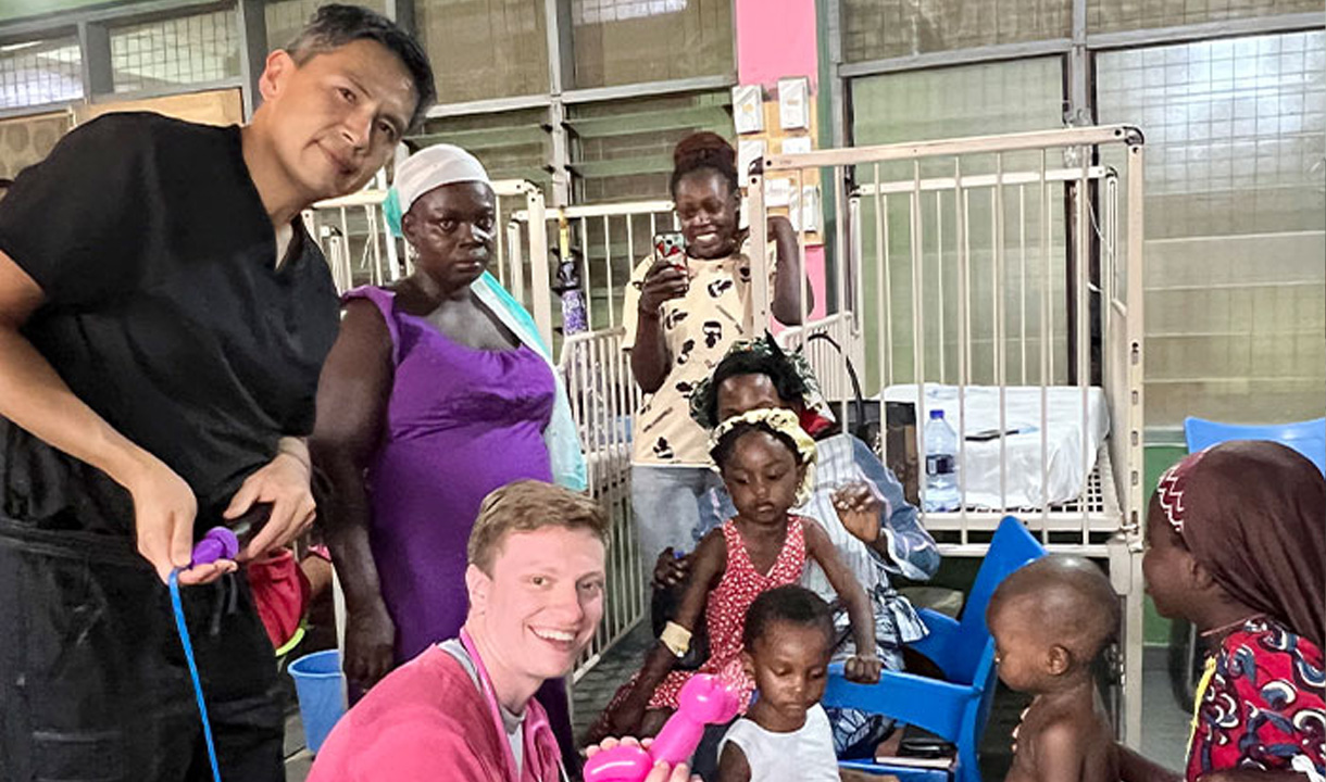 Medical students taking picture with patient and their children.