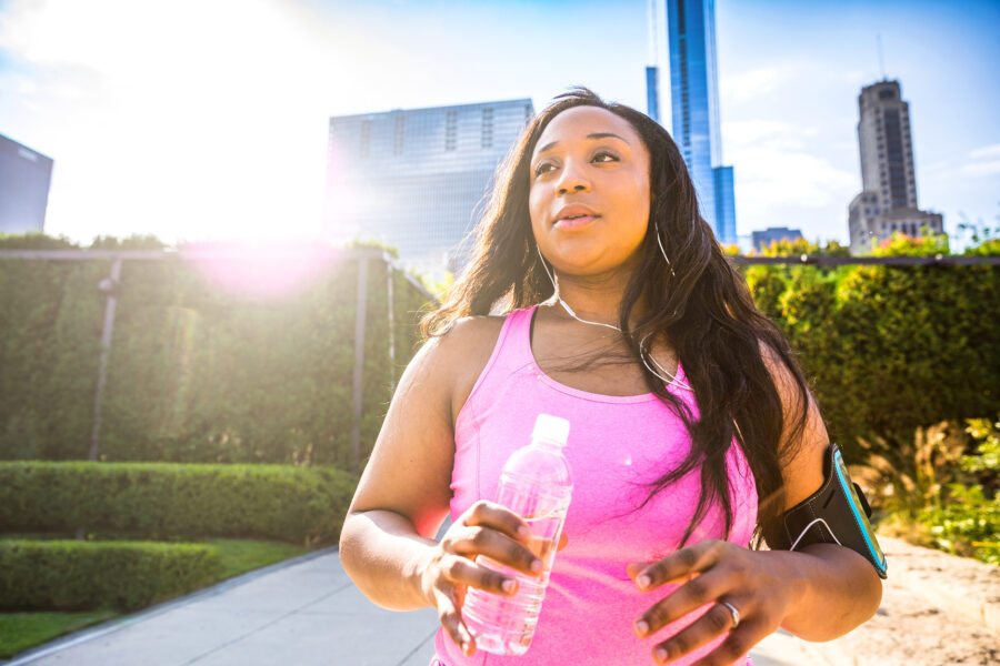 Woman walking outdoors holding a water bottle