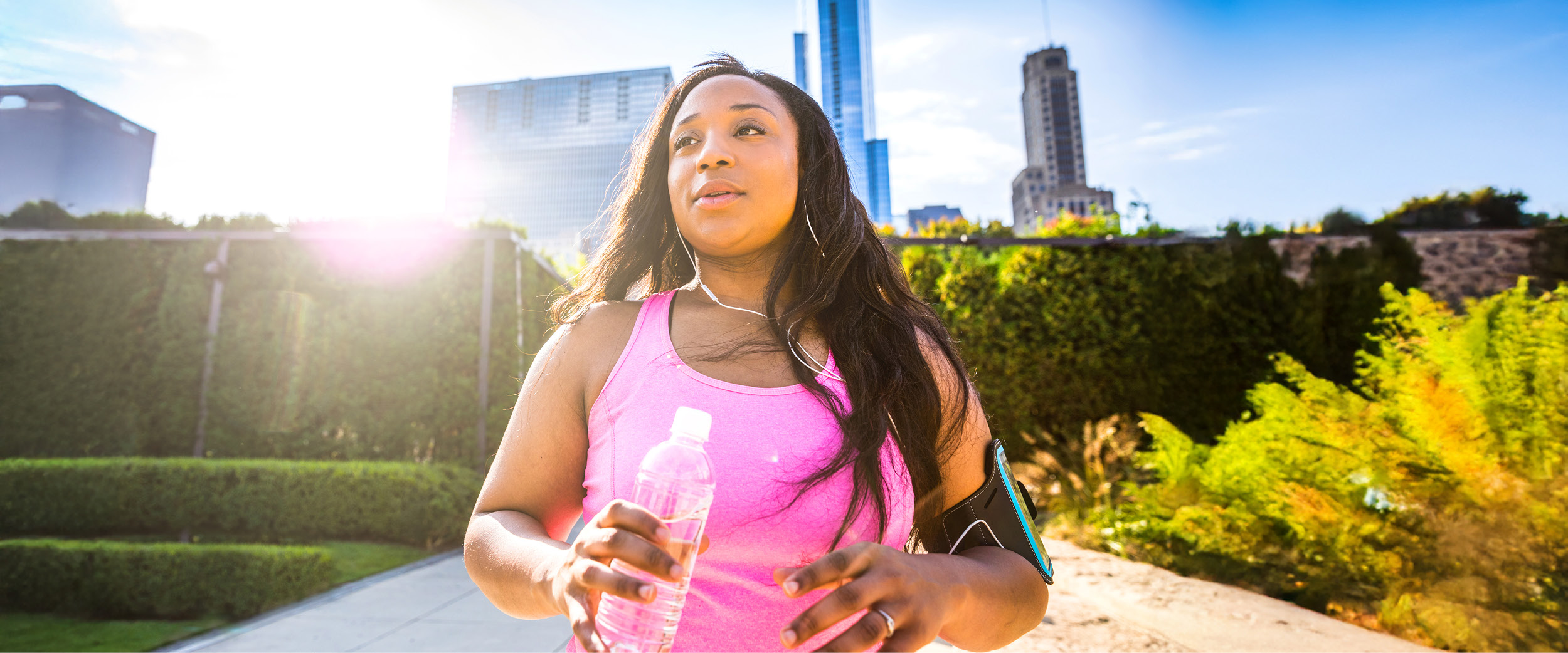 Woman walking outdoors holding water bottle