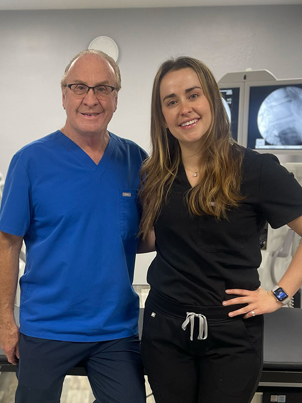 New York Tech alumni who are father and daughter pose in front of medical equipment.