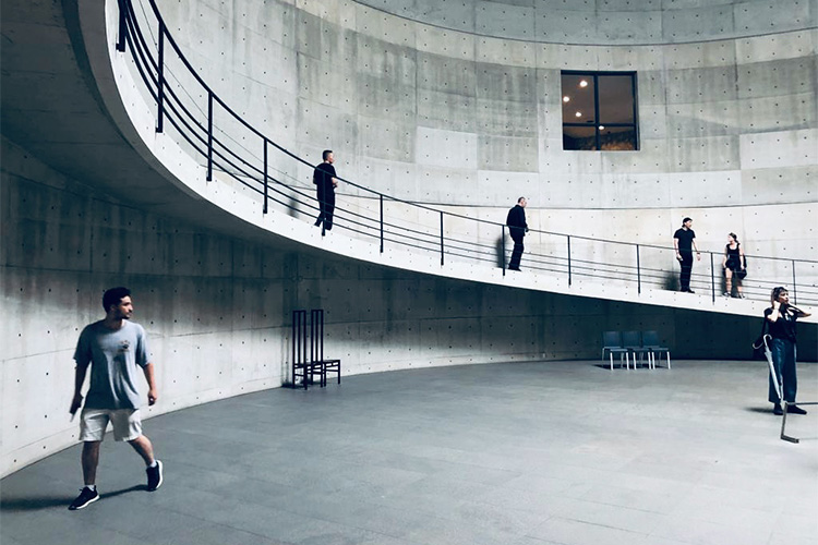 A photo of the interior of the Benesse House Museum on the island of Naoshima, Japan, showing stark concrete form and a rising ramp.