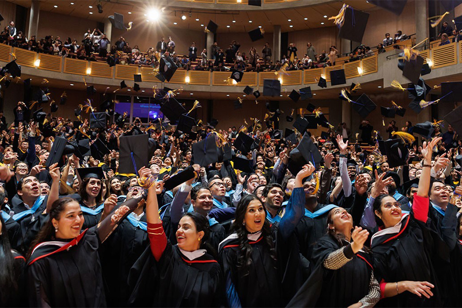 Crowd throwing caps into the air.