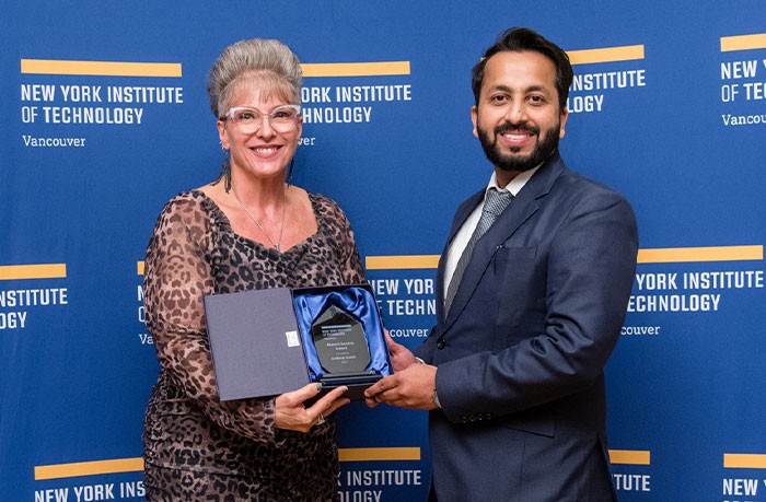 DIRECTOR OF STUDENT AFFAIRS SHANNON SVINGEN-JONES PRESENTS JASDEEP GULATI WITH THE ALUMNI SERVICES AWARD.