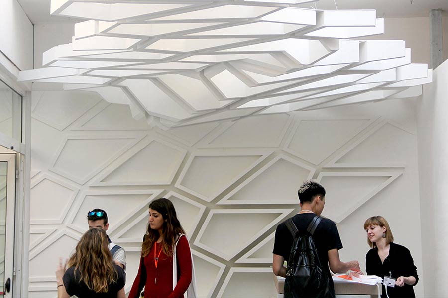 Users in a space with three dimensional geometric pattern wall