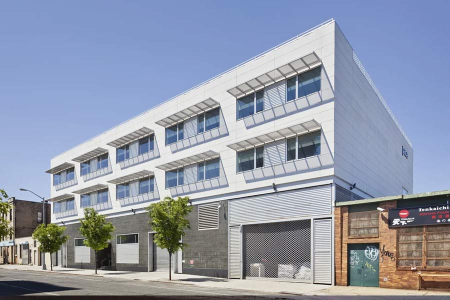 A modern apartment exterior. Made of brick, metal and glass