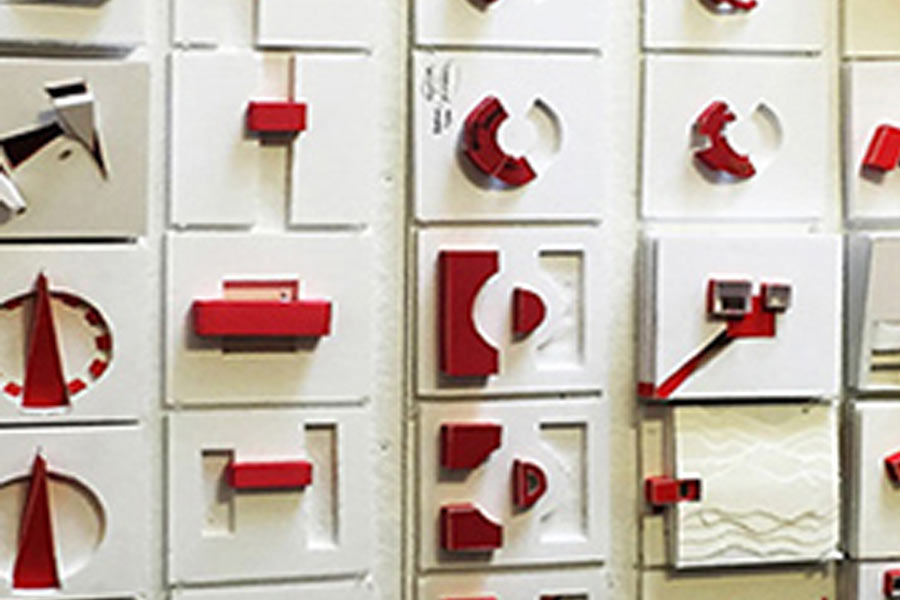 A wall of drawers with shapes and symbols in red on the face of each drawer