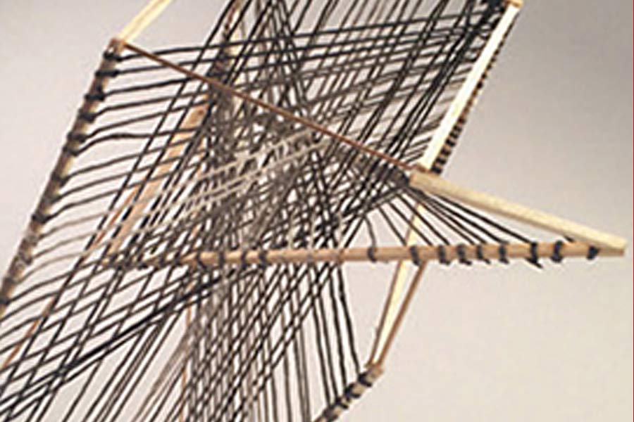 crossing threads speared on wood