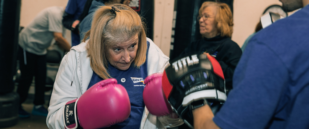 Woman boxing wearing pink boxing gloves