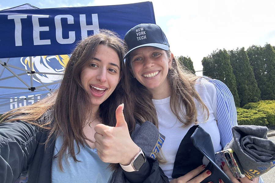 Two students smile with New York Tech swag.