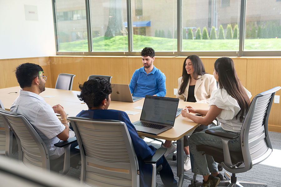 A group of people meet in a conference room.
