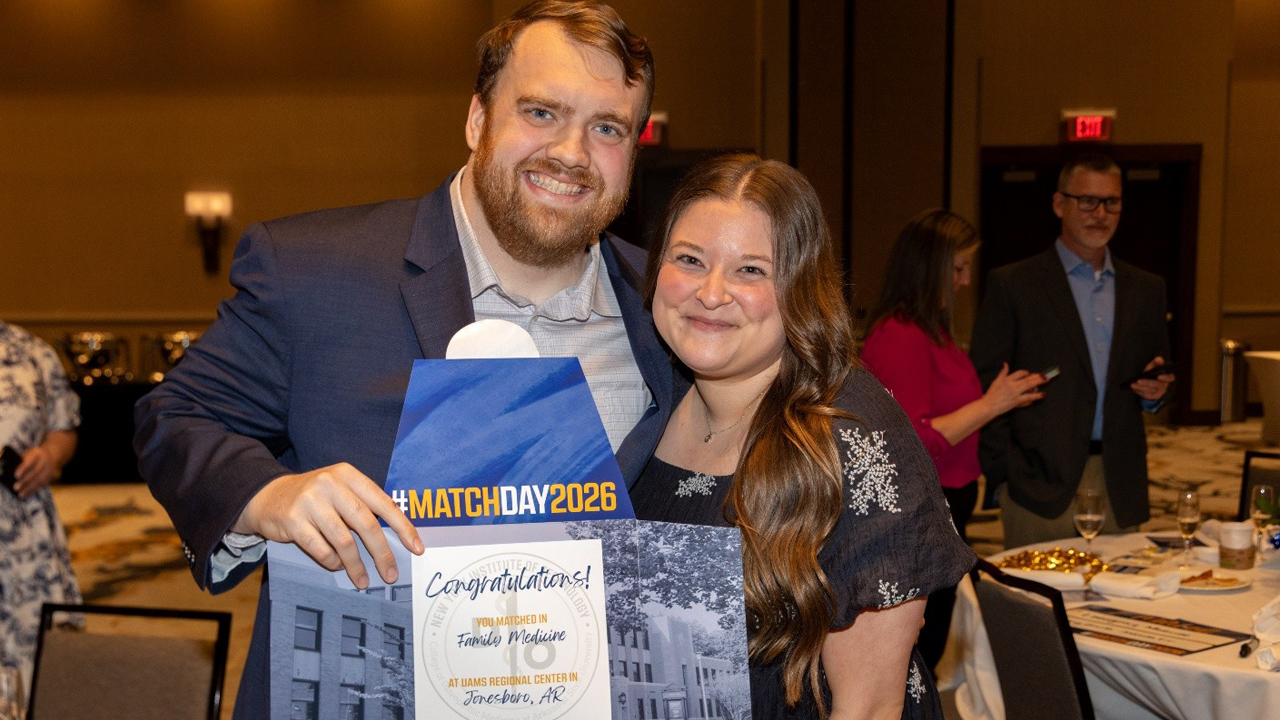 An NYITCOM student and his wife holding sign with his match