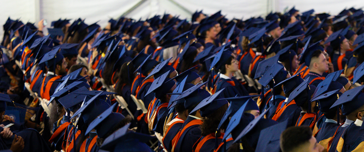 Students sitting wearing regalia