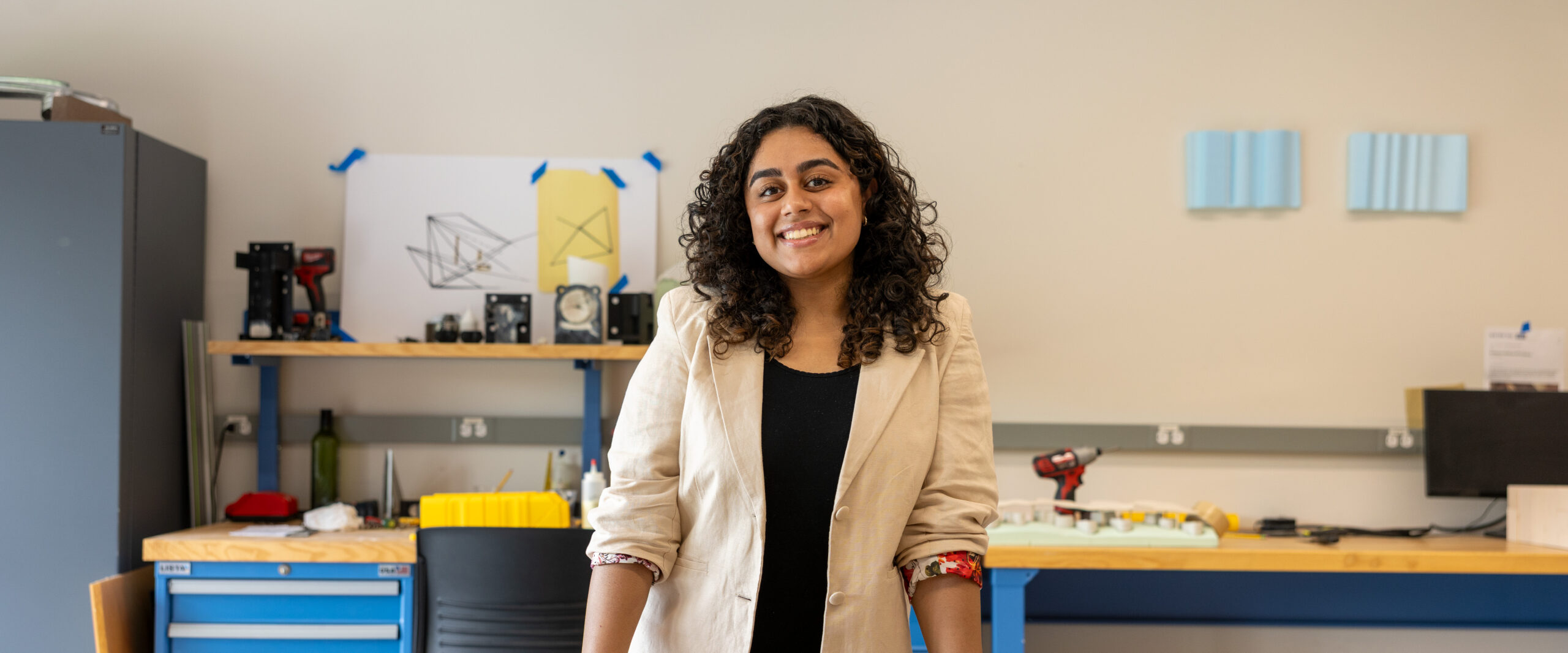 Daisy Madaan standing behind a desk