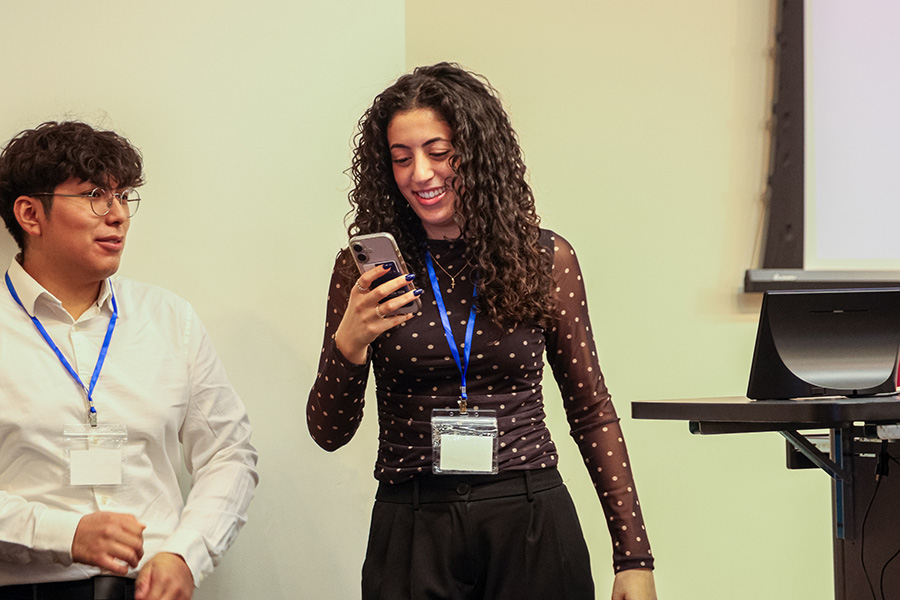 Social Media Ambassador looks at her phone at an event.