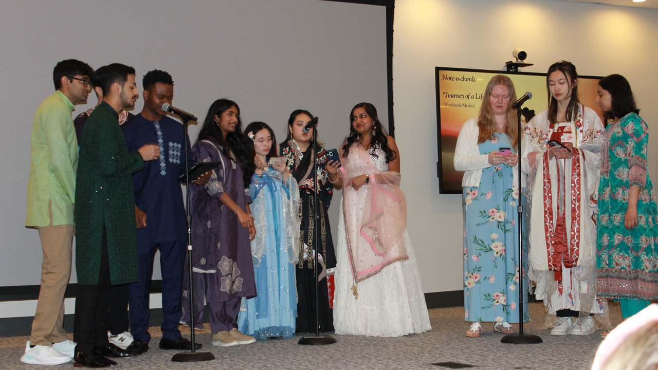 Students wearing traditional clothing and singing