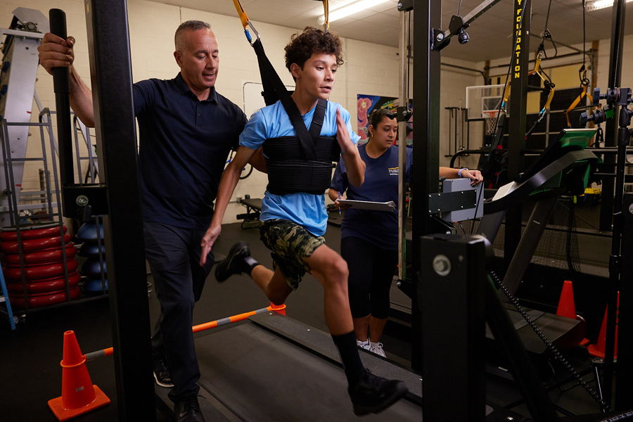 Alexander Lopez spotting a student on a treadmill
