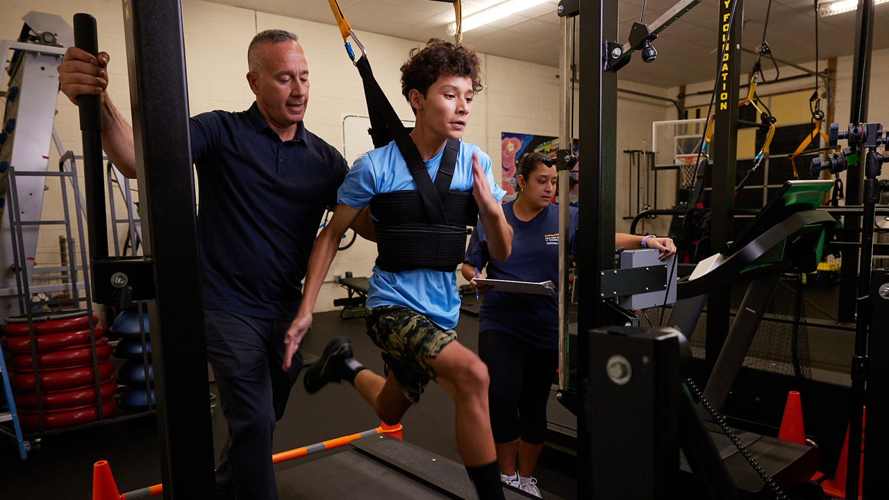 Alexander Lopez spotting a child on a treadmill