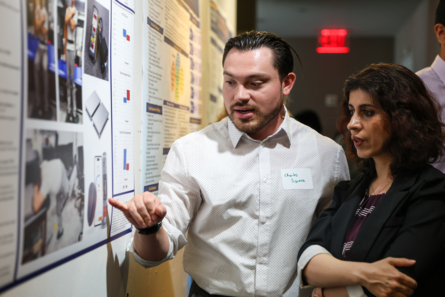 Student explaining his poster to an attendee