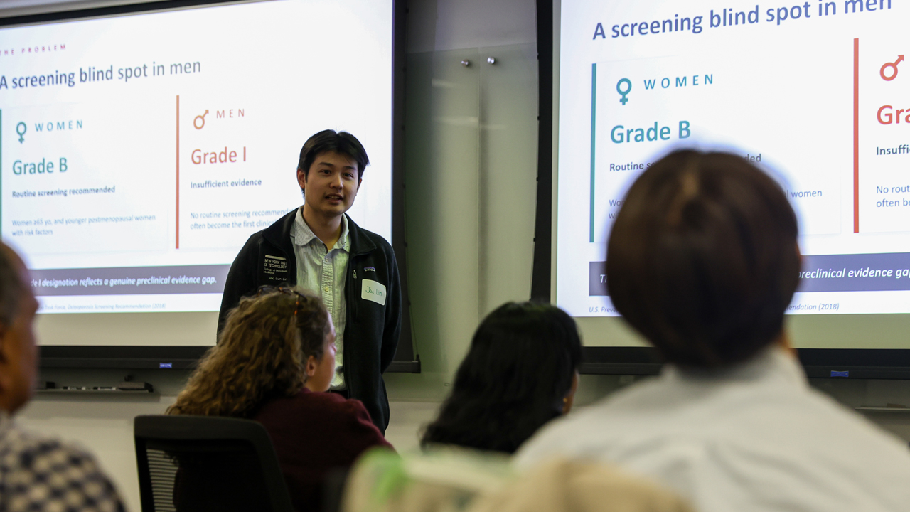 Student presenting his research to attendees