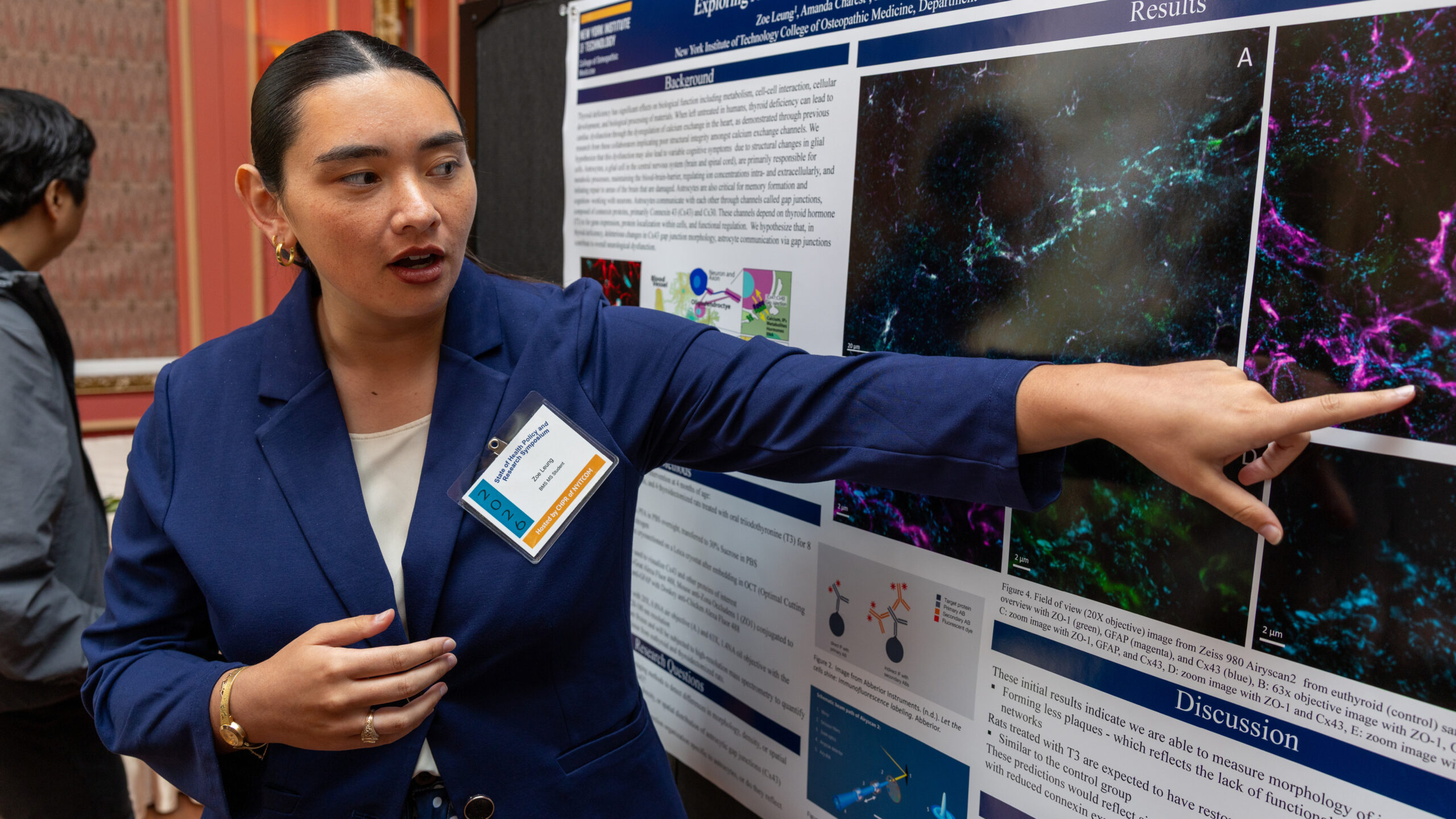NYITCOM student standing next to her poster