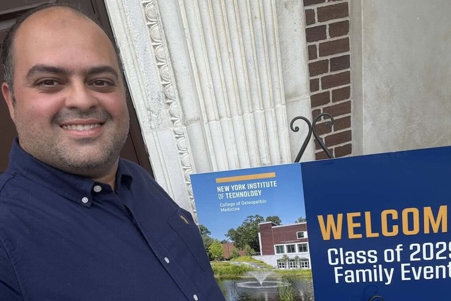 Belal Badawy smiling in-front of a welcome sign