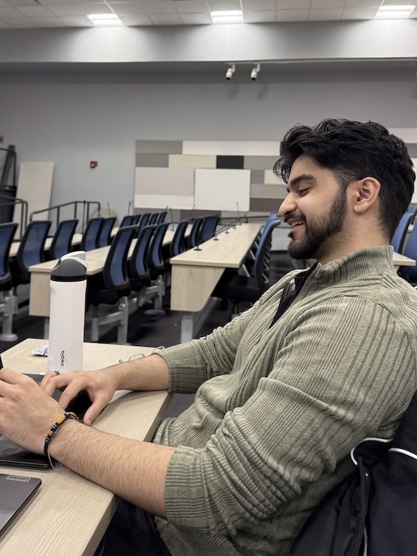 Taimoor Chaudhry in a classroom on a laptop