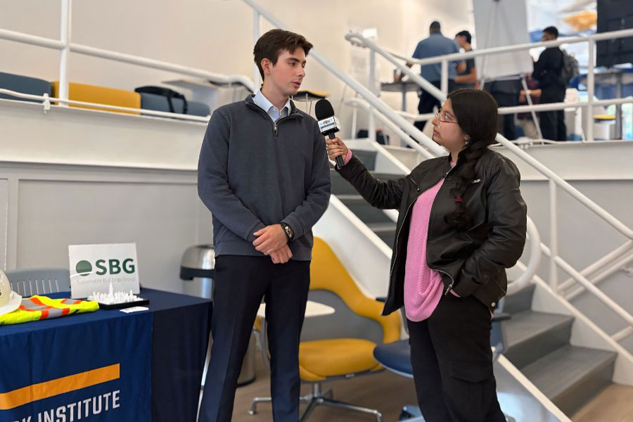 A student being interviewed about their project by another student