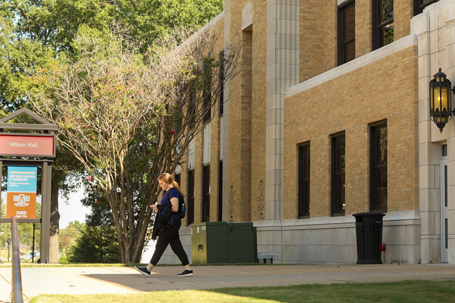 Student walking by a building