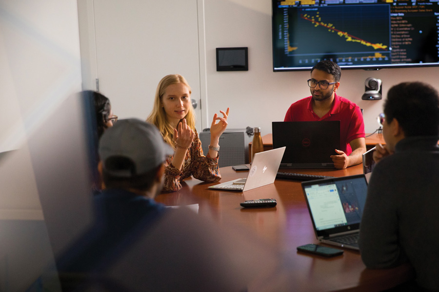 Students sitting at a conference table with laptops.