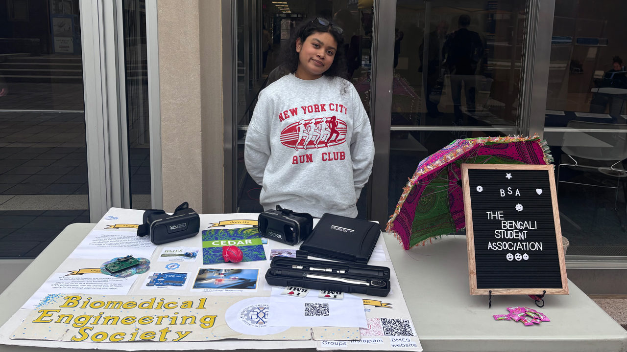Aiesha Ayaana Hamid standing behind a table outside